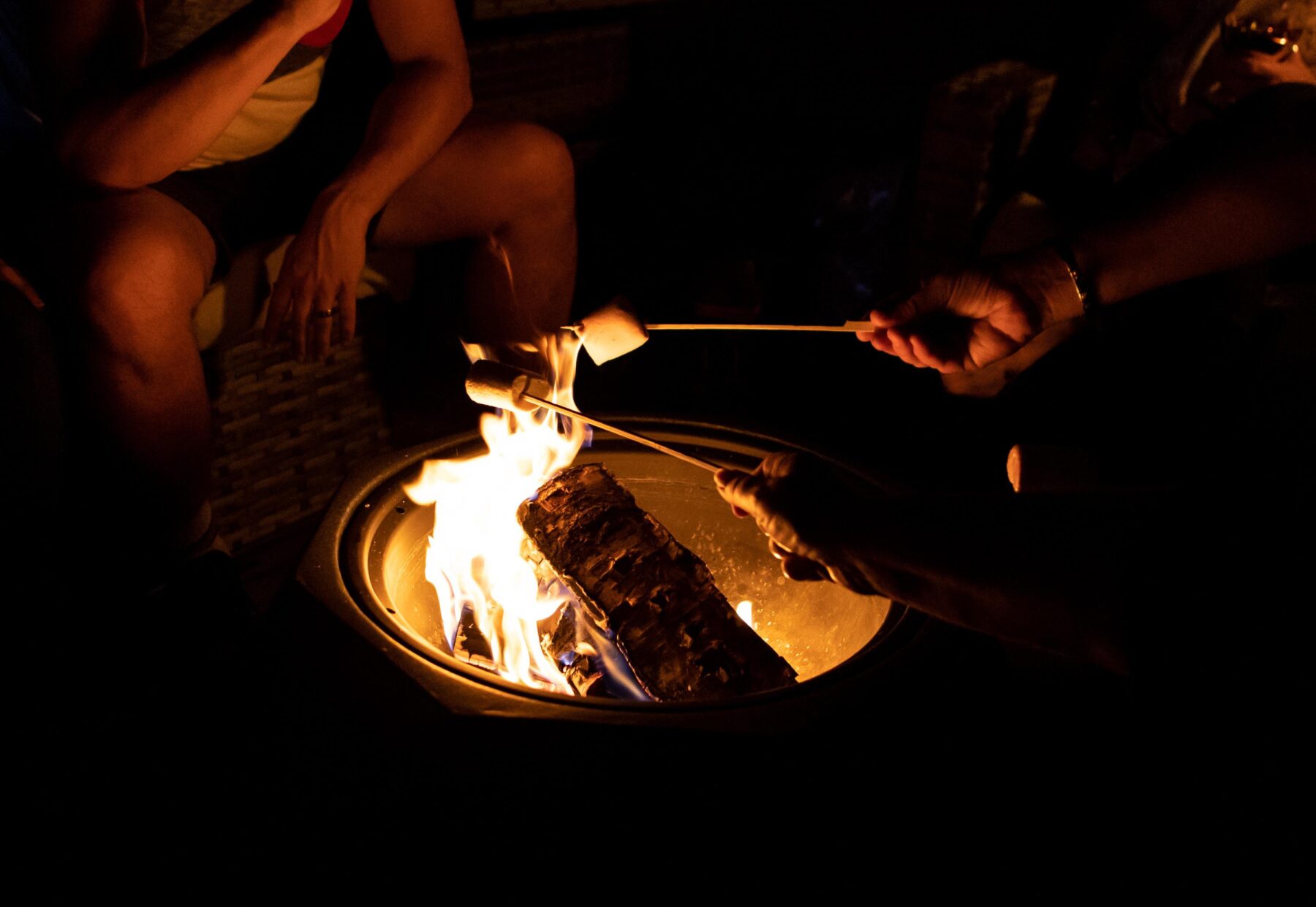 Family gathered around a glowing fire pit on a gravel seating area at dusk, showing a DIY gravel fire pit and gravel patio